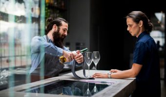 bartender-pouring-wine-glass_53876-83607